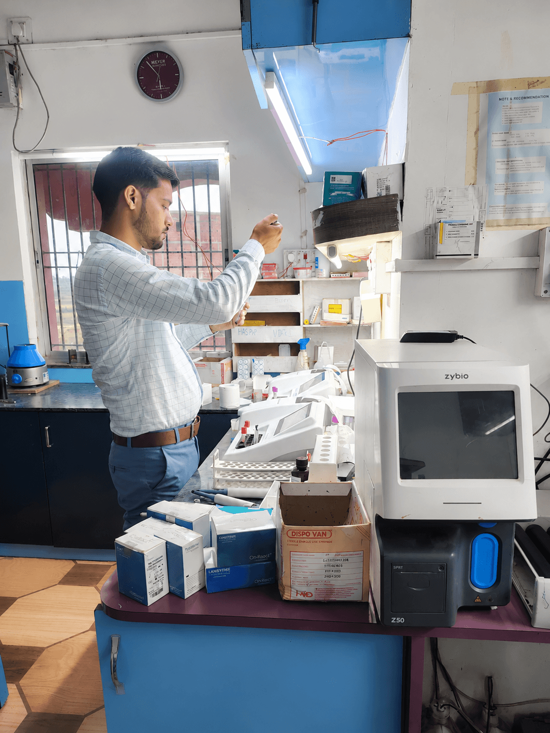 Laboratory technician operating diagnostic testing equipment at Dubey Nursing Home